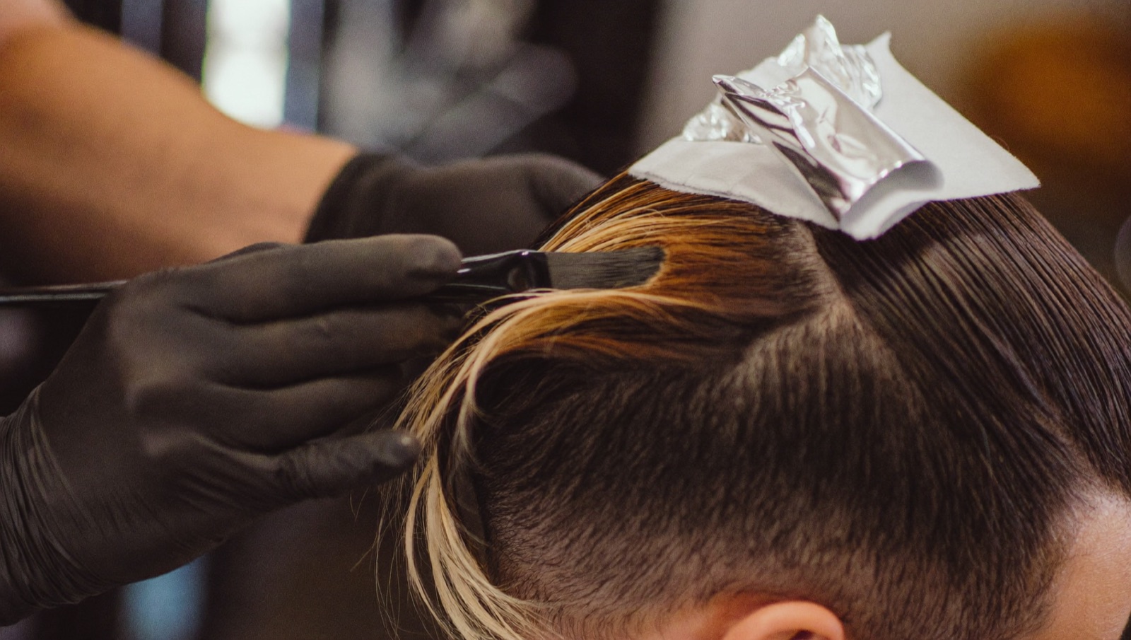 Illustrative image of a colourist painting balayage at the chair