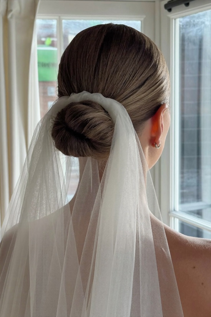 A bride with a sleek low bun and a veil
