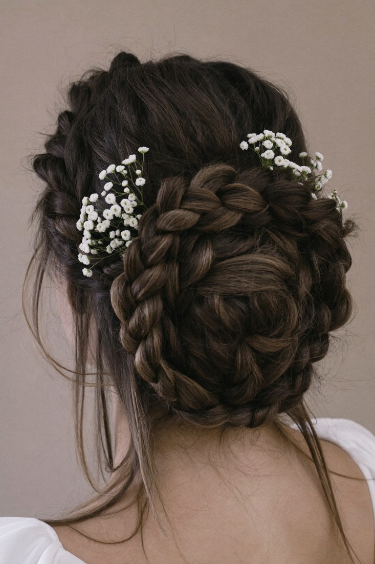 A braided crown updo with small flowers